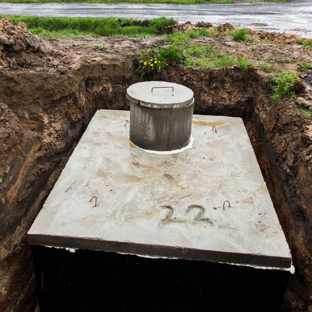 An image of a rectangular concrete septic tank in the ground.
